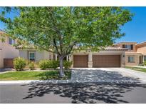 Beautiful single-story home with a well-manicured lawn and a two-car garage, shaded by a large tree at 6423 Grayback Dr, North Las Vegas, NV 89084