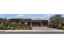 Beautiful single-story home showcasing a two-car garage, a stone facade, and professionally landscaped front yard at 7072 Arabian Ridge St, Las Vegas, NV 89131