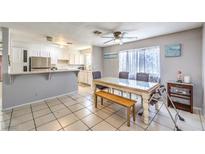Bright dining area featuring tile floors, a ceiling fan, and a dining table with seating and an adjacent kitchen at 844 Balzar Ave, Las Vegas, NV 89106