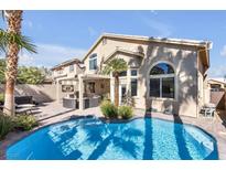 Inviting backyard pool with palm trees, outdoor seating, and attached spa create a private oasis at 9417 Grenville Ave, Las Vegas, NV 89134