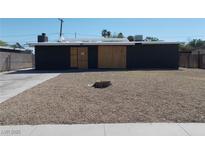 Exterior view of boarded up single story house and rock groundcover at 1912 Statz St, North Las Vegas, NV 89030