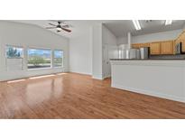 Bright living room features wood floors, large windows, ceiling fan, and an open floor plan at 2596 Lazy Saddle Dr, Henderson, NV 89002