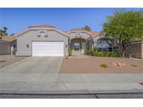 Charming single-story home featuring a red tile roof, landscaped front yard and a two car garage at 401 Obsidian St, Las Vegas, NV 89145