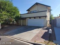 Charming two-story home featuring a two-car garage and desert landscaping at 4760 Woodridge Rd, Las Vegas, NV 89121