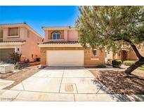 Two-story tan home with a two-car garage and desert landscaping in front at 6747 Gold Yarrow St, Las Vegas, NV 89148