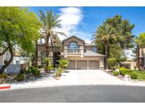 Charming two-story home featuring desert landscaping with palm trees and a three-car garage at 8800 Cortile Dr, Las Vegas, NV 89134