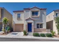 Charming two-story home with a tan stucco exterior, a blue front door, and a cozy front porch at 9140 Entrancing Ave, Las Vegas, NV 89149