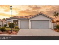 Charming single-story home featuring a tile roof, manicured landscaping, and a two-car garage at 1613 Shadow Rock Dr, Las Vegas, NV 89117