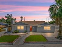 Charming single-story home with a red front door, manicured lawn, and mature palm tree at 1700 E Oakey Blvd, Las Vegas, NV 89104