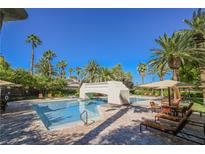 Beautiful community pool with bridge and relaxing lounge chairs and umbrellas surrounded by palm trees in a desert community at 2050 W Warm Springs Rd # 4322, Henderson, NV 89014