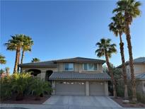 Charming two-story home featuring a neutral palette, tile roof, attached two-car garage, and mature palm trees at 2440 Ping Dr, Henderson, NV 89074