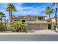 Beautiful two-story home with a tile roof, three car garage, and lush desert landscaping at 2440 Ping Dr, Henderson, NV 89074