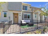 Charming townhouse with a cozy, fenced front patio seating area and a modern, neutral color scheme at 2598 Polar White Ave, North Las Vegas, NV 89086
