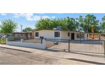 Charming single-story home with white exterior, desert landscaping, and a secure iron fence at 3320 Osage Ave, Las Vegas, NV 89101