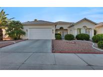 Charming single-story home with a two-car garage, desert landscaping, and a tiled roof at 4005 Poppy Fields Dr, Las Vegas, NV 89129