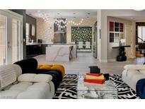 Open-concept living room with modern decor, light wood floors, and a view into the kitchen at 464 Beardsley Cir, Henderson, NV 89052