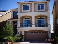 Inviting three-story home boasting a neutral stucco exterior, balcony, and an attached two-car garage at 5889 Thistle Meadow Ave, Las Vegas, NV 89139