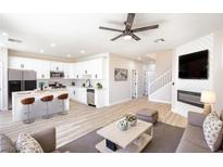 Open-concept living room featuring modern furnishings, white cabinets, and an electric fireplace at 6387 Azurelyn Ave, Las Vegas, NV 89122