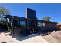 Charming single-story home featuring a dark exterior, landscaped yard, and a spacious driveway at 709 Evergreen Cir, Las Vegas, NV 89107