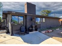 Unique single story home with a brick chimney, concrete walkway, and decorative plants by the front door at 709 Evergreen Cir, Las Vegas, NV 89107