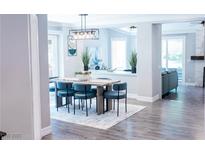 Bright dining room featuring modern light fixture, table with blue chairs, and an open floor plan at 7607 Boca Raton Dr, Las Vegas, NV 89113