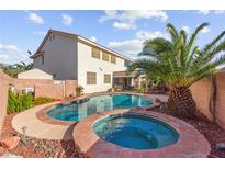 Inviting backyard pool and spa with lush landscaping and privacy fencing at 977 Courtney Valley St, Henderson, NV 89052