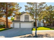 Charming two-story home with a well-manicured lawn, mature trees, and a three-car garage at 9937 Whalers Landing Ct, Las Vegas, NV 89117