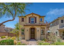 Charming two-story home featuring an arched entryway, brown shutters, and professionally landscaped front yard at 1130 Blissful Plains Ave, North Las Vegas, NV 89086