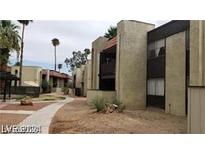 View of the apartment complex exterior with desert landscaping, palm trees, and walkway at 1405 Vegas Valley Dr # 360, Las Vegas, NV 89169