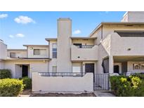 Inviting multi-level townhouse featuring a cozy gated patio area and well-maintained landscaping at 1628 Justin Ct # 18, Henderson, NV 89011