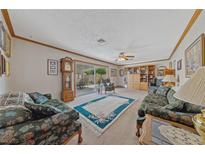 Cozy living room with floral furniture, ceiling fan, and sliding glass doors to the backyard at 22 Jade Cir, Las Vegas, NV 89106