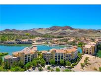 Stunning aerial view of a lakeside community with mountain backdrop and meticulously designed buildings under a clear blue sky at 29 Montelago Blvd # 520, Henderson, NV 89011