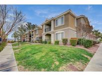 Beautiful two-story condo building with a well-manicured lawn and balcony views on a partly cloudy day at 2900 Sunridge Heights Pkwy # 518, Henderson, NV 89052