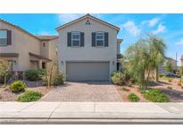 Charming two-story home with a brick driveway, gray exterior, and manicured landscaping at 2935 Saltillo Ln, Las Vegas, NV 89121
