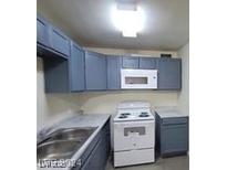 Functional kitchen featuring sleek cabinets, white microwave, and electric range at 304 Orland St # 39, Las Vegas, NV 89107