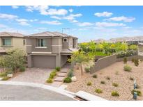 Charming two-story home featuring a brick driveway, two-car garage, and landscaped front yard with desert landscaping at 438 Wind Poppy St, Las Vegas, NV 89138