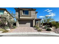 Beautiful two-story home showcasing a neutral color, complemented by a brick driveway and well-manicured landscaping at 438 Wind Poppy St, Las Vegas, NV 89138