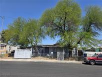 Charming single-story home with mature trees and a chain-link fenced yard at 4794 Saguaro Way, Las Vegas, NV 89121