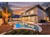 Beautiful backyard pool and spa with outdoor lighting, covered patio, and manicured landscaping at sunset at 516 Pinnacle Heights Ln, Las Vegas, NV 89144