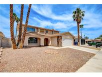 Charming two-story home featuring desert landscaping and palm trees at 7004 Powderhorn Cir, Las Vegas, NV 89128