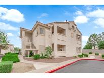 Charming condo building with tan stucco and a well-maintained landscape under a bright blue, cloudy sky at 855 N Stephanie St # 2121, Henderson, NV 89014