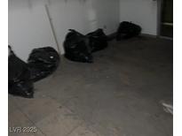 Living room needing renovation with trash bags and old floors at 1405 Vegas Valley Dr # 378, Las Vegas, NV 89169
