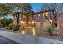Stunning three-car garage home with stone accents, mature trees, and illuminated windows at dusk at 2124 Pont National Dr, Henderson, NV 89044