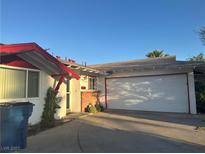 Charming single-story home featuring a two-car garage and a brick accent wall near the front entrance at 3382 Berwyck St, Las Vegas, NV 89121