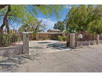 Gated entrance with mature trees and a circular driveway providing an estate-like feel at 5854 Sheila Ave, Las Vegas, NV 89108