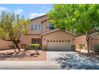 Charming two-story home with a two-car garage, desert landscaping, and mature trees at 6125 Paddleboat St, North Las Vegas, NV 89031
