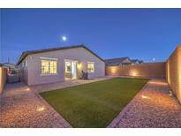 Well-lit backyard with artificial turf, stone landscaping, and an outdoor grill, perfect for entertaining at 617 Sylvan St, Henderson, NV 89002