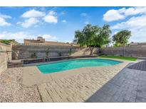 Backyard view of a sparkling in-ground pool with lush landscaping and hardscape at 6791 Greengrove Dr, Las Vegas, NV 89103