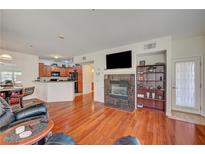 Bright living room featuring hardwood floors, a fireplace, and an open layout to the kitchen at 689 Bay View Dr # 1311, Boulder City, NV 89005