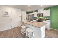 Bright kitchen with stainless steel appliances, white cabinets and a large center island with counter seating at 6928 Wrightshire St # 19, Las Vegas, NV 89166